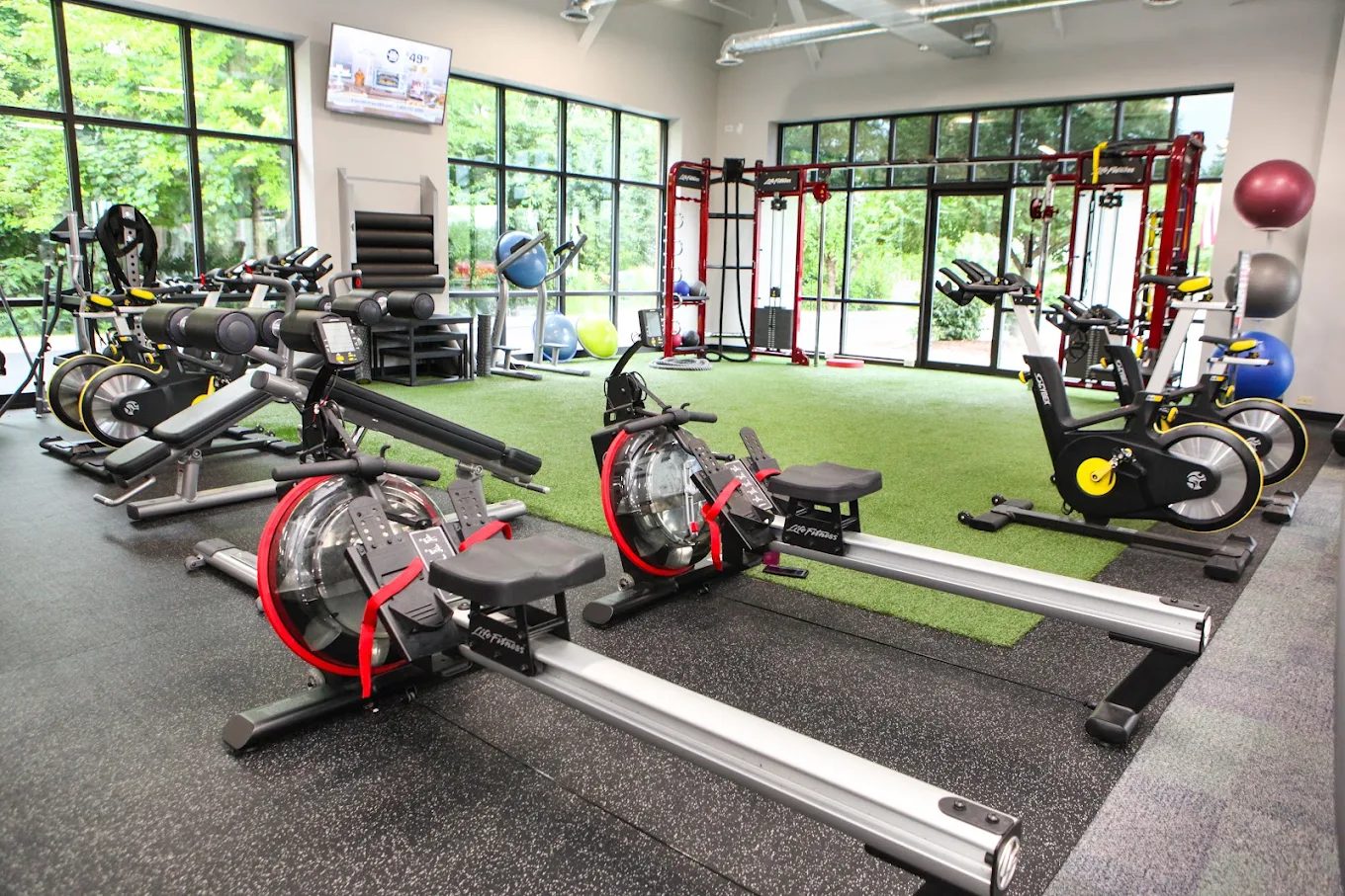 Bright training area with rowers, bikes, and turf
